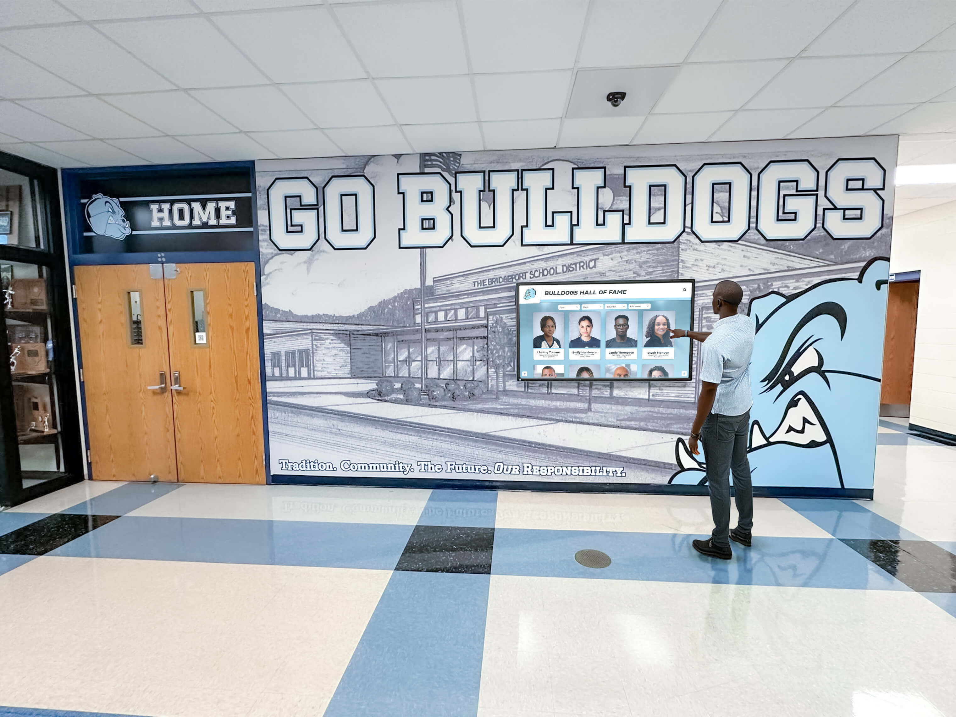 Man interacting with hall of fame screen in school hallway