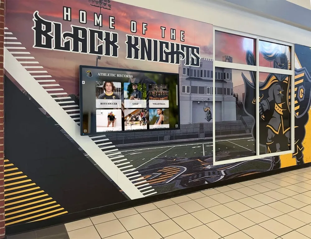 School hallway featuring Black Knights athletic mural with digital records display Athletic recognition in school hallway